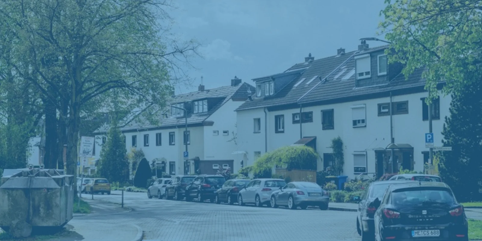 Wohnstraße mit einer Reihe von Wohnhäusern und geparkten Autos